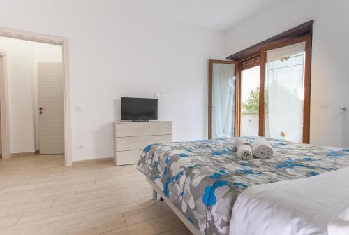 a white bedroom with a bed and a television at Alloggio turistico a casa di Paoletto in Fiumicino