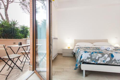 a bedroom with a bed and a balcony with a table at Alloggio turistico a casa di Paoletto in Fiumicino