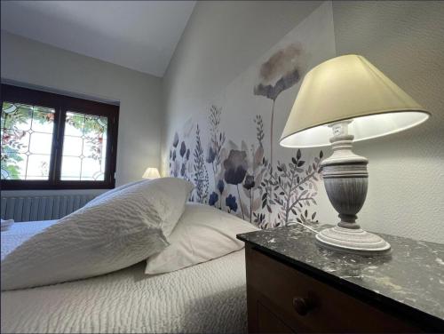 une chambre avec un lit avec une lampe sur une table dans l'établissement Gayaloé, à Dhuizon