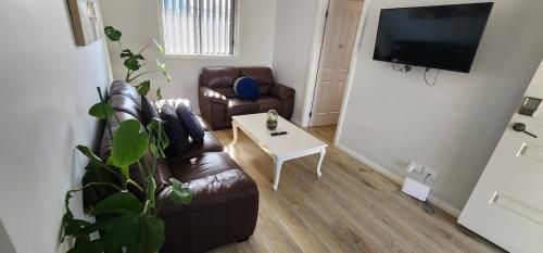 a living room with a couch and a table at 2BR Wollongong Home 10mins walk to Hospital & Train Station with Free Parking and Fast Wi-Fi in Wollongong
