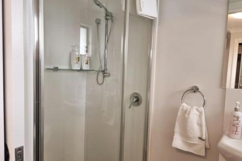 a shower with a glass door in a bathroom at 2BR Wollongong Home 10mins walk to Hospital & Train Station with Free Parking and Fast Wi-Fi in Wollongong