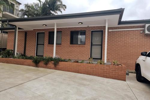 a brick house with a car parked in front of it at 2BR Wollongong Home 10mins walk to Hospital & Train Station with Free Parking and Fast Wi-Fi in Wollongong