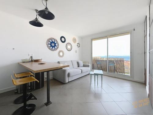 un salon blanc avec une table et un canapé dans l'établissement Appartement à Montredon - Vue sur Mer - Les Frères de la Loc', à Marseille
