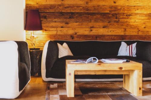 a living room with a couch and a coffee table at Auhof Wirtshaus & Suiten in Kaprun