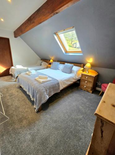 a attic bedroom with two beds and a window at Ash Cottage in Hope
