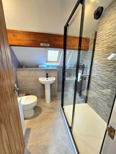 a bathroom with a toilet and a glass shower at Ash Cottage in Hope