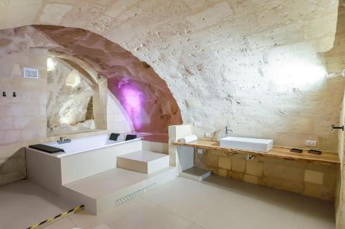 a bathroom with two sinks and a stone wall at Angelica Home - Central apartment in Matera in Matera