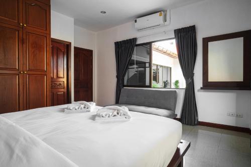 a bedroom with a white bed and a window at Luxury Massarossa Pool Villa Pattaya-21 in Pattaya