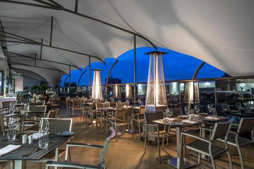a restaurant with tables and chairs on a roof at Radisson Blu Hotel, Nairobi Upper Hill in Nairobi