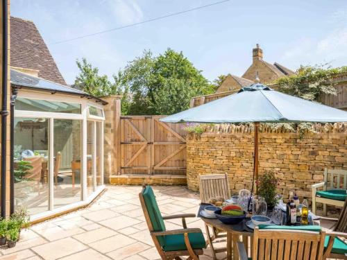 a patio with a table with an umbrella at East Leaze in Chipping Campden