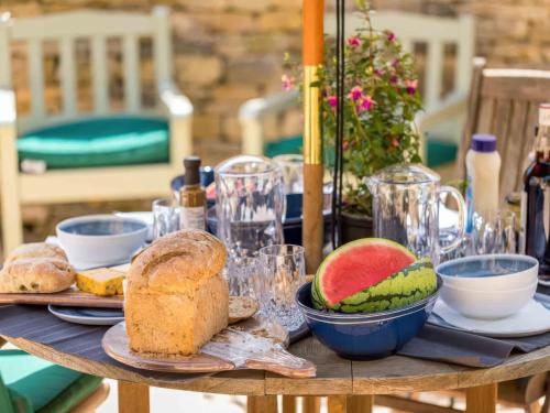 a table with a plate of bread and fruit on it at East Leaze in Chipping Campden