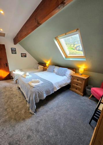 a bedroom with two beds and a skylight at Birch Cottage in Hope