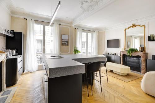 - une cuisine avec une grande île dans le salon dans l'établissement Prestige Marais, à Paris