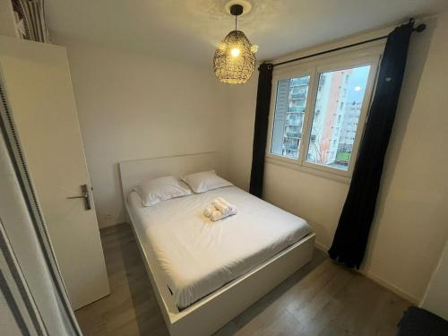 un petit lit dans une chambre avec une fenêtre dans l'établissement L'Alpin, 2 chambres, Parking, Vue montagne, à Grenoble