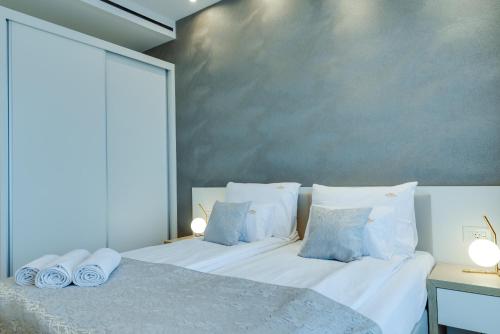 a bedroom with a bed with white sheets and pillows at ZEPTERME Luxury Apartments & Studios by CENTRAL in Vrnjačka Banja