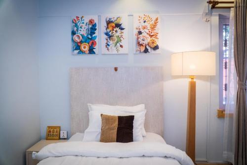 a bedroom with a bed with two paintings on the wall at Bishramalaya Villa by Dosro Home in Pātan