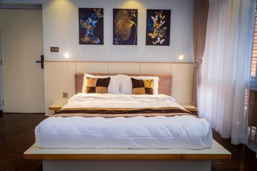 a bedroom with a large bed and some pictures on the wall at Bishramalaya Villa by Dosro Home in Pātan