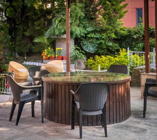 a patio with chairs and a circular table with a fountain at Bishramalaya Villa by Dosro Home in Pātan