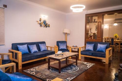 a living room with blue couches and a table at Bishramalaya Villa by Dosro Home in Pātan