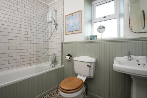a bathroom with a toilet and a sink at Driftwood Cottage by Coast & Country Stays in Seahouses
