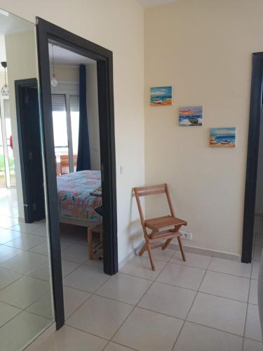 a room with a mirror and a chair and a bed at Bahia Golf Beach in Bouznika