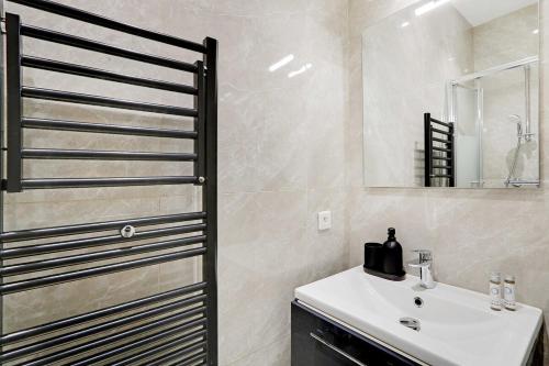 une salle de bain avec un lavabo blanc et un miroir dans l'établissement Wonderful 6P apartment - Amiral, à Paris