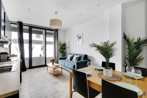 un salon avec une table et un canapé bleu dans l'établissement Wonderful 6P apartment - Amiral, à Paris