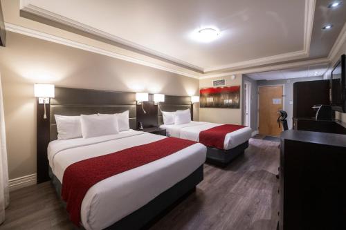 Ένα ή περισσότερα κρεβάτια σε δωμάτιο στο Hotel & Suites Le Dauphin Drummondville