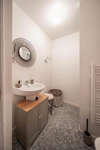 une salle de bain avec un lavabo et un miroir dans l'établissement L'appartement Cosy, à Tournus