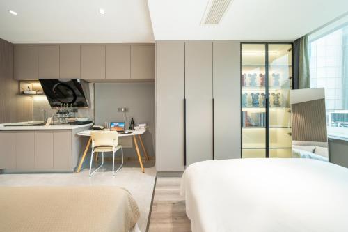 a bedroom and a kitchen with a bed and a table at Today Aparthotel West Lujiazui Shanghai in Shanghai