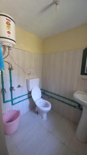 a bathroom with a toilet and a sink at Lahaul Home Stay Sumnam in Tāndi