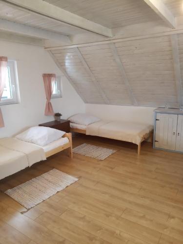 a bedroom with two beds in a attic at Dom na Łabędziej in Charzykowy