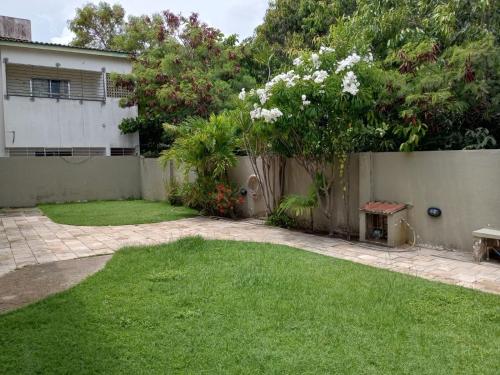einen Hinterhof mit einem Zaun und einem Rasenplatz in der Unterkunft Espaço Vila Verde in Paulista