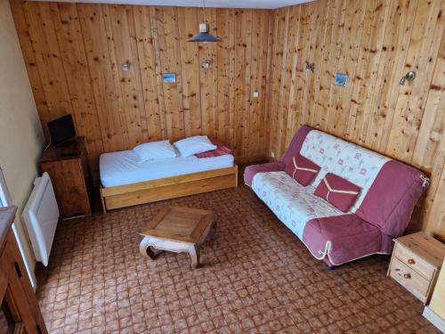 une petite chambre avec un lit et une chaise dans l'établissement Au Platelet, aux Rousses