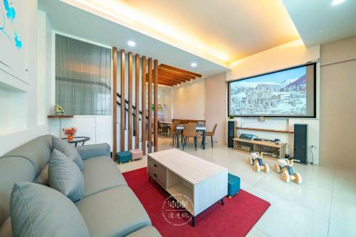 a living room with a couch and a flat screen tv at 卡弧灣民宿 4-20人包棟 in Wujie