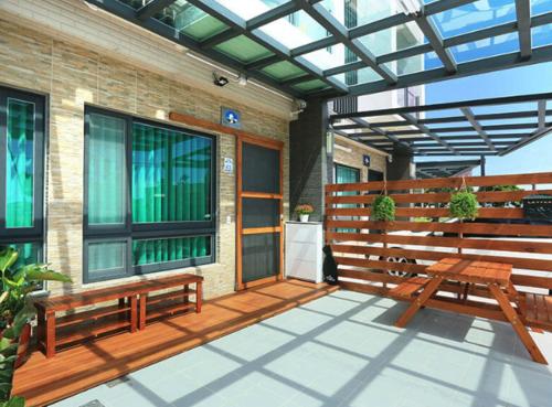 a patio with two benches and a building at 卡弧灣民宿 4-20人包棟 in Wujie