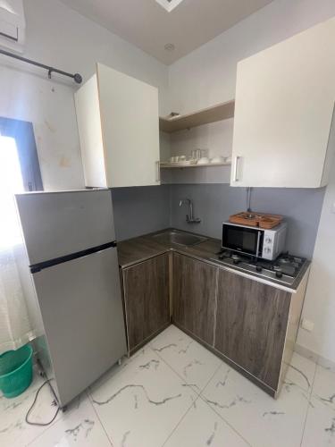 a kitchen with white cabinets and a microwave at Mondialaw in Toubab Dialaw