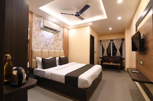 KalyaniN B Sonar Bangla Hotel的一间带床、电视和沙发的卧室