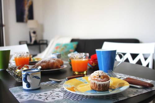 a table with a muffin on a plate and drinks at Palazzo Sandù Dimora nel Borgo in San Nicola Arcella