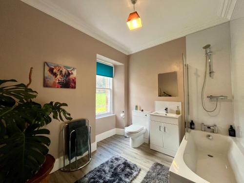 a bathroom with a tub and a toilet and a sink at The Farmhouse Snug in Spean Bridge
