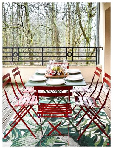 - une table avec des chaises et des verres sur une terrasse couverte dans l'établissement Élégant Duplex terrasse et parking, à Le Plessis-Trévise