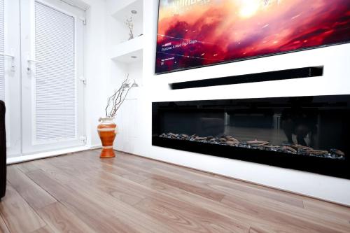 a fireplace in a living room with a tv on the wall at Cozy Place in Salford, Sleeps 8, 4 Bedroom, 5 Beds in Manchester