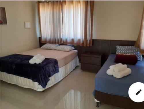 a bedroom with two beds with towels on them at Domiciliar RP - Casa com piscina in São Gonçalo Do Rio Preto