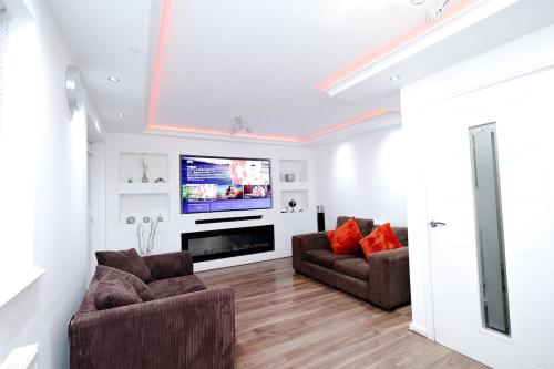 a living room with two couches and a flat screen tv at Cozy Place in Salford, Sleeps 8, 4 Bedroom, 5 Beds in Manchester