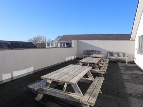 three picnic tables on the roof of a building at Plas Gwylan in Rhosneigr