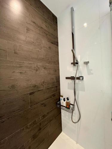 a bathroom with a wooden accent wall and a shower at El Horizonte de Benicassim II, Descubre esta lujosa propiedad a los pies del Mediterraneo in Benicàssim