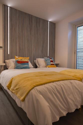 a bedroom with a large bed with yellow blankets and pillows at Sunbeam House 1 Morecambe Pet Friendly in Morecambe