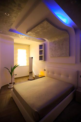 a bedroom with a large bed with blue lights at La Suite di FiloGà in Vieste