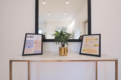 a table with two framed signs and a potted plant on it at Missori Luxury Apartments in Milan