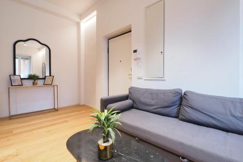 a living room with a blue couch and a mirror at Missori Luxury Apartments in Milan